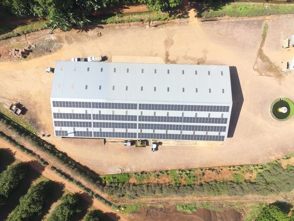 Aerial shot of warehouse with solar panels on roof.